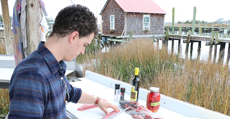Harvest chef Tyler Kinnett cuts a banded rudder fish -- something he'd never heard of -- while visiting Abundant Seafood in South Carolina last year.