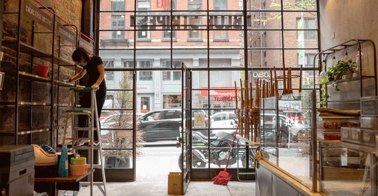 An employee cleans a restaurant in New York City preparing to reopen for takeout