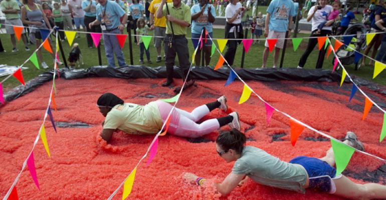 Competitors crawl through strawberry jelly