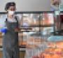 Restaurant worker wearing mask in a bakery 
