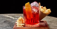 Negroni cocktail with a popcorn cone clipped to the glass